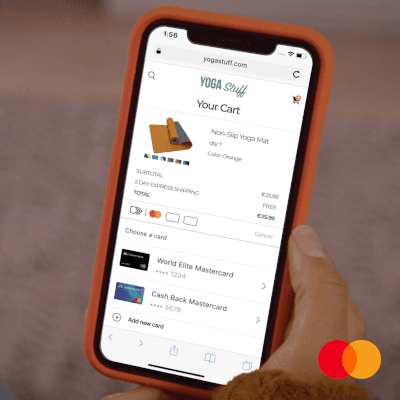 Person hält Smartphone mit Einkaufswagen, zeigt orangefarbene rutschfeste Yogamatte, zwei Mastercard-Optionen zur Auswahl.