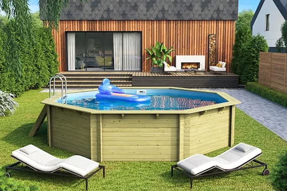 Achter-Pool im Garten vor Terrasse mit Haus, Leiter und Luftmatratze im Wasser, zwei Liegen auf dem Rasen