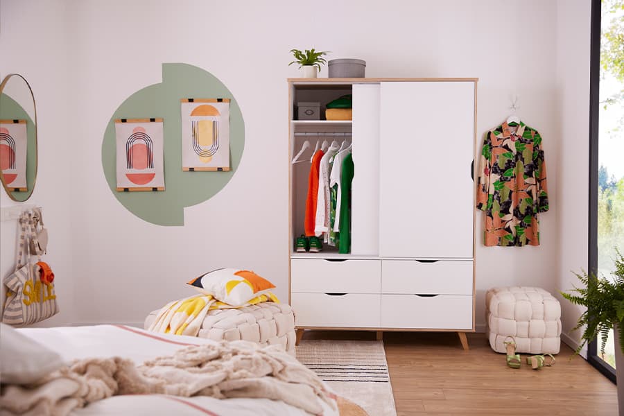 Modernes Schlafzimmer mit einem offenen Kleiderschrank, dekorativen Wandbildern und einem bequemen Bett.