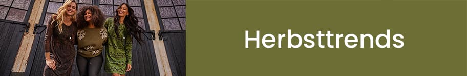 Herbsttrends – Drei Frauen in herbstlicher Kleidung stehen nebeneinander vor einem großen Fenster.