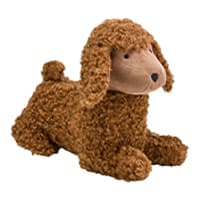 Braunes Kuscheltier in Form eines Hundes mit lockigem Fell und einem hellbraunen Gesicht, liegt auf dem Bauch mit erhobenem Kopf.