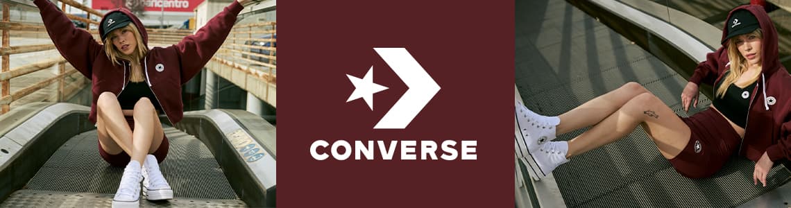 Converse – Frau in burgunderrotem Hoodie und Shorts, sitzt auf einer Rolltreppe und trägt weiße High-Top-Sneaker