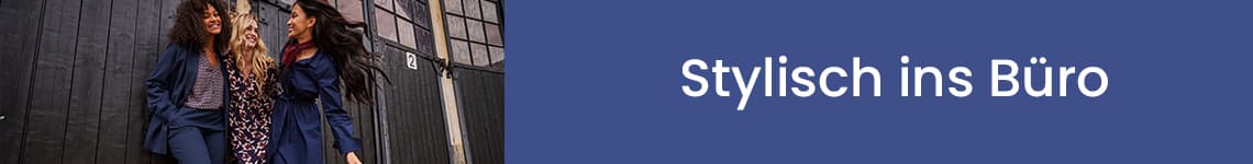 Stylisch ins Büro – Drei Frauen in eleganter Kleidung, zwei in blauen Mänteln, eine in gemustertem Kleid, stehen lächelnd vor schwarzer Wand.