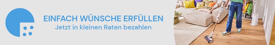 EINFACH WÜNSCHE ERFÜLLEN – Jetzt in kleinen Raten bezahlen – Person staubsaugt Wohnzimmer mit Sofa und bunten Kissen