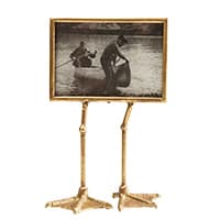 Rahmen auf Vogelbeinen – Schwarz-Weiß-Bild von zwei Personen beim Bootfahren auf einem Fluss