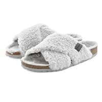 Weiße Hausschuhe mit Kreuzriemen und weicher Plüschoberfläche auf brauner Sohle, Ansicht von vorne und seitlich