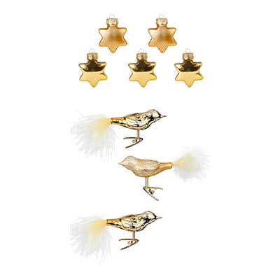 Sechs goldene Sternanhänger und drei goldene Vogelanhänger mit weißen Schwanzfedern auf weißem Hintergrund