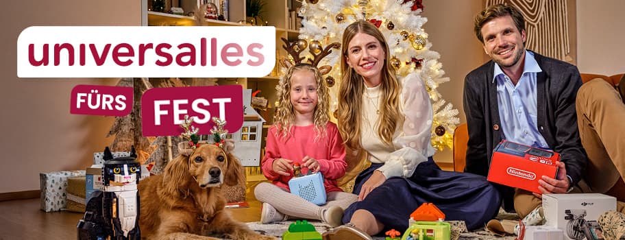 universalles fürs Fest – Familie sitzt vor Weihnachtsbaum, hält Geschenke, Hund mit Rentiergeweih-Spielzeug, Spielzeug auf dem Boden