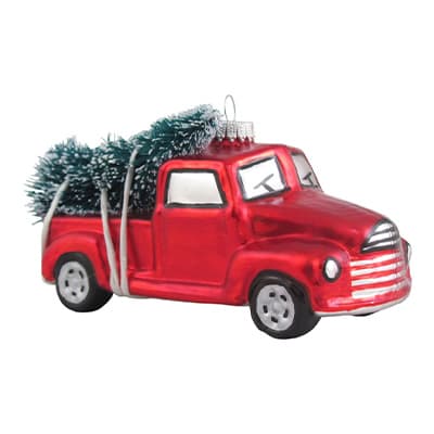 Rot glänzender Spielzeug-Lkw mit grüner Tanne auf der Ladefläche