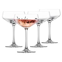 Vier elegante Cocktailgläser, eines davon gefüllt mit rosafarbenem Getränk, alle auf transparentem Stiel.