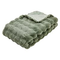 Gefaltete grüne Decke mit flauschiger Struktur und einer Ecke, die das Innere der Decke zeigt.