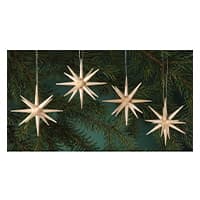 Vier strohgedeckte Weihnachtssterne hängen an einem grünen Tannenbaum.