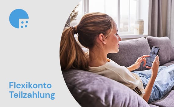 Flexikonto Teilzahlung – Frau sitzt auf grauem Sofa und blickt auf ihr Smartphone
