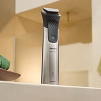 Elektrischer Trimmer steht auf einem hellen Waschbeckenrand in einem modernen Badezimmer