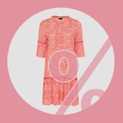 Prozentzeichen vor einem knielangen, gemusterten Kleid mit halblangen Ärmeln auf einfarbigem Hintergrund
