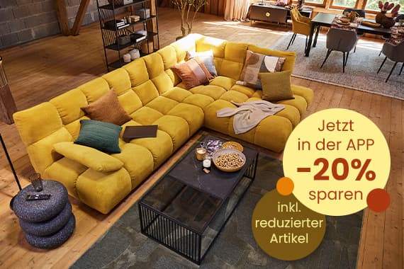 Jetzt in der App 20 % sparen – großes gelbes Ecksofa mit Kissen in gemütlichem Wohnzimmer mit Couchtisch und Snacks