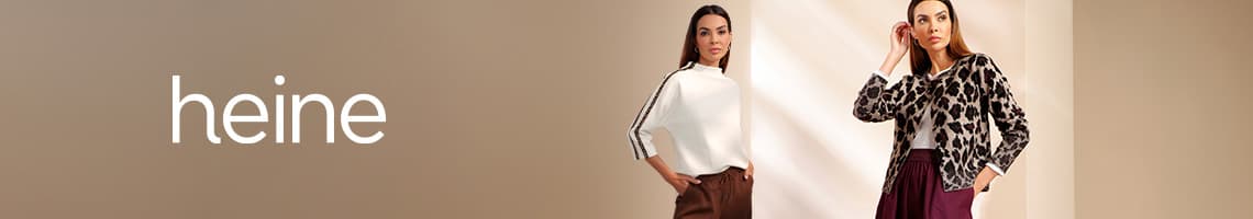 heine – zwei Frauen in herbstlicher Mode, eine im weißen Pullover, eine mit gemusterter Jacke und dunkler Hose