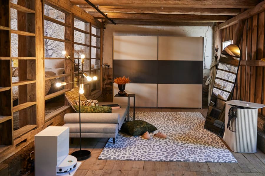 Wohnzimmer im rustikalen Loft mit Sofa, Stehlampe, großem Schrank, Teppich und schräg stehendem Spiegel