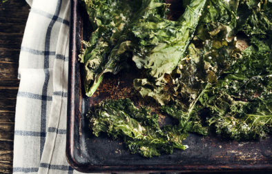 Crispy cheese and chili kale chips on baking tray. Toned image