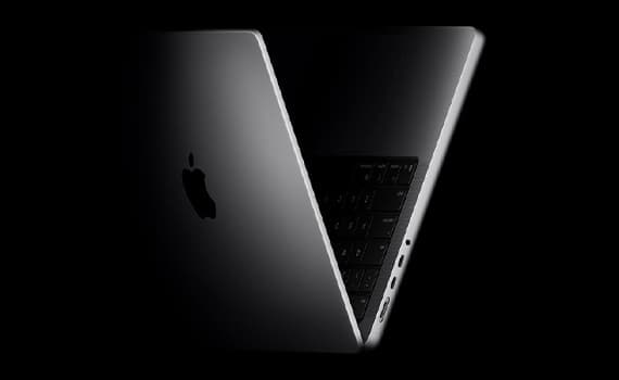 Teilweise geöffnetes silbernes MacBook mit Apple-Logo, schwarzer Tastatur und sichtbaren Ports auf schwarzem Hintergrund