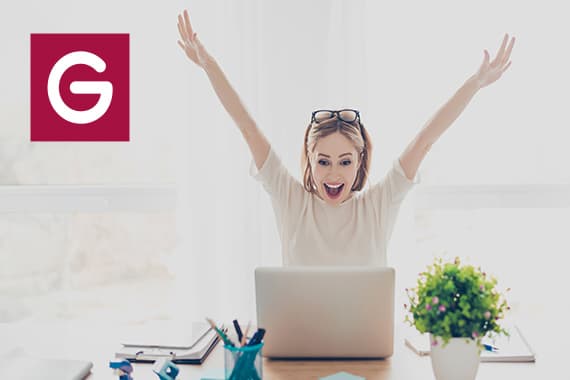 Person am Schreibtisch mit Laptop, jubelt mit erhobenen Armen. Büroartikel und Pflanze im Vordergrund. Logo links.