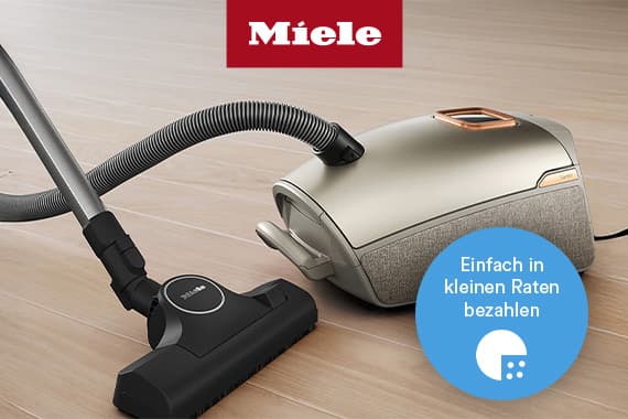 Einfach in kleinen Raten bezahlen – Miele Bodenstaubsauger mit Schlauch und Düse auf hellem Boden